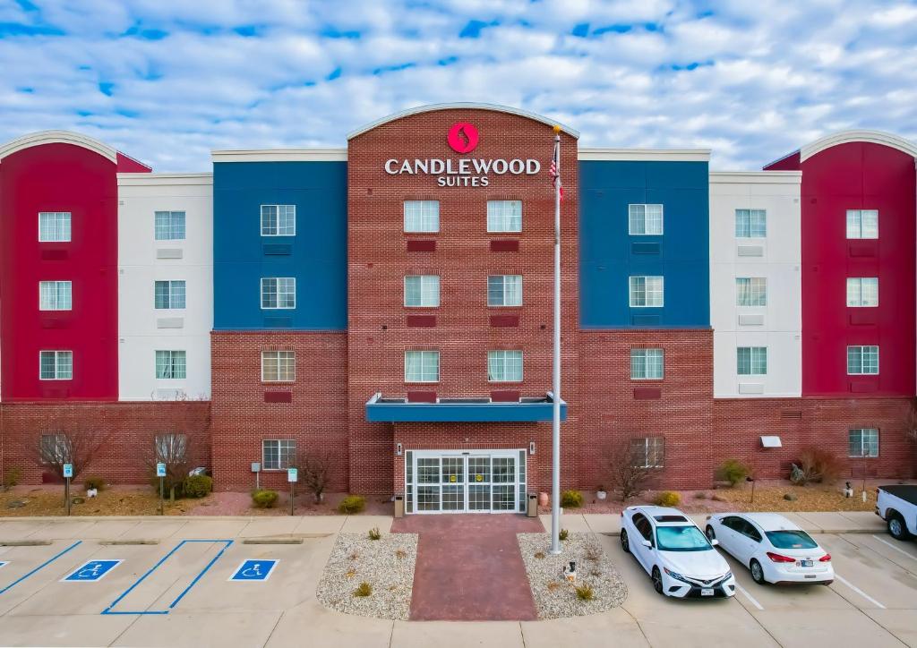 ein Gebäude mit Autos auf einem Parkplatz in der Unterkunft Candlewood Suites Lafayette, an IHG Hotel in Lafayette