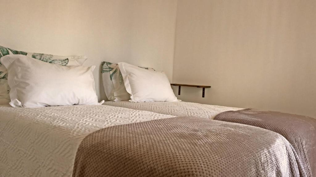 ヴィラ・ノヴァ・デ・ミルフォンテスにあるNa Casa da Fátimaの- 白い枕付きのベッド2台(1室)