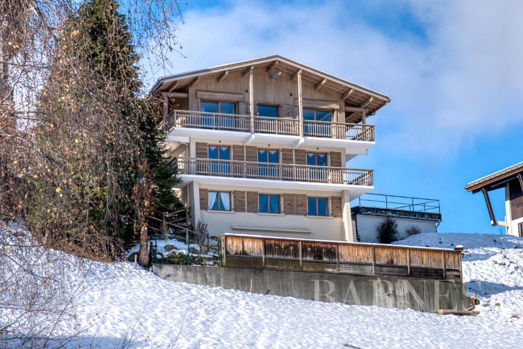 um edifício no topo de uma colina coberta de neve em Apartments in Chalet Nessa em Combloux