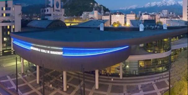 een groot gebouw met een blauw dak in een stad bij Gold Europole-Gare in Grenoble