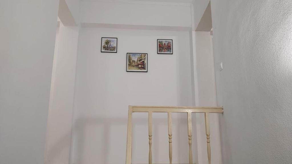a white room with three pictures on the wall at Camera de la Bunici - o poarta catre oriunde 