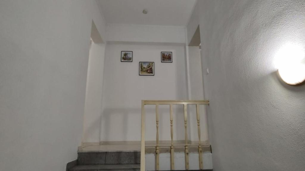a hallway with a staircase with pictures on the wall at Camera de la Bunici - o poarta catre oriunde 