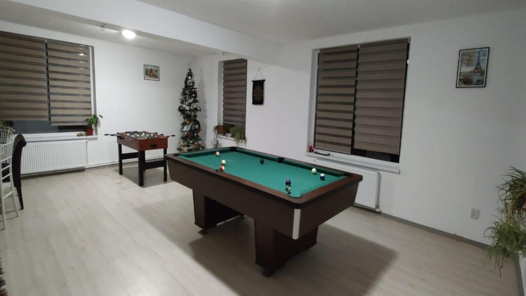 a living room with a pool table and a christmas tree at Camera de la Bunici - o poarta catre oriunde 
