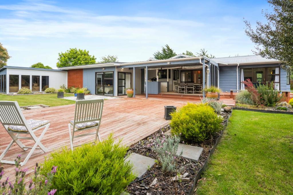 マーティンボロにあるRegent Retreat - Martinborough Holiday Homeの木製デッキに椅子2脚付きの家