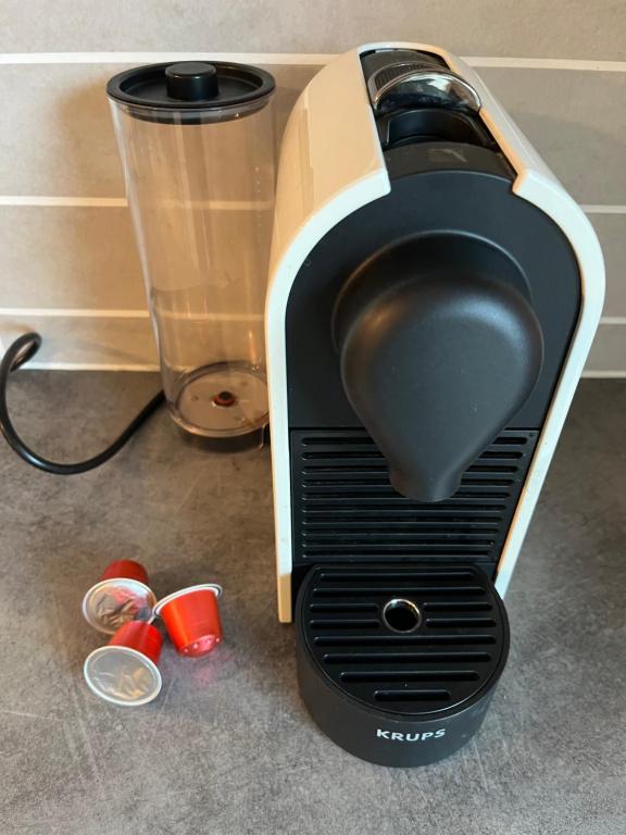 a toaster is sitting on the floor next to a cup at Entre Lac d'Annecy et montagnes, golf et parapente à pieds in Talloires