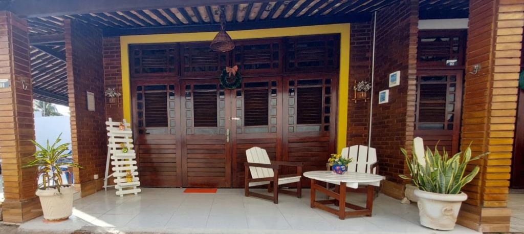 Chalé aconchegante na Barra de São Miguel في بارا دي ساو ميجيل: شرفة منزل مع طاولة وكراسي