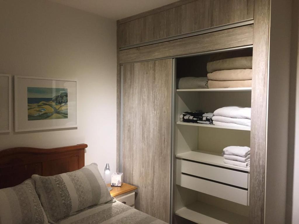 1 dormitorio con armario con toallas y 1 cama en Apto Península excelente ubicación** en Punta del Este