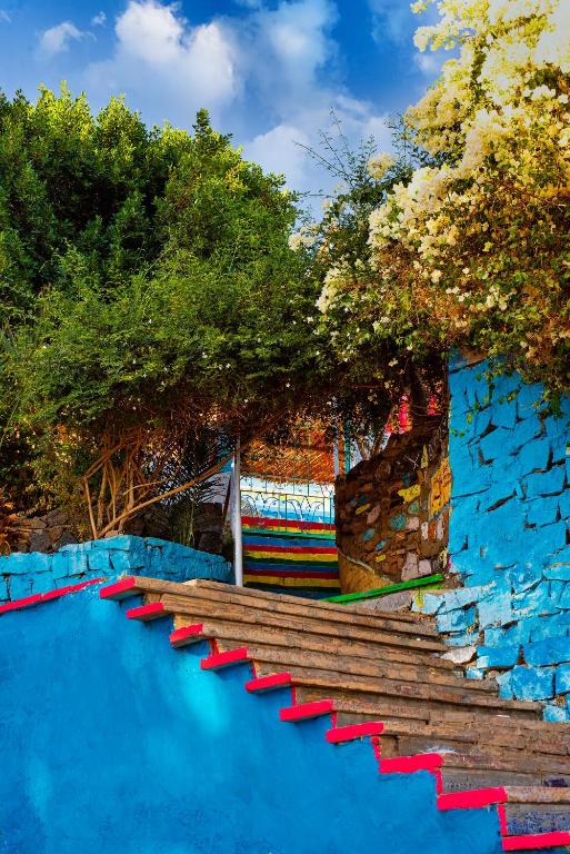 un gruppo di sedie rosse su un pavimento blu di Nubian Beach - حسن فوكس a Aswan