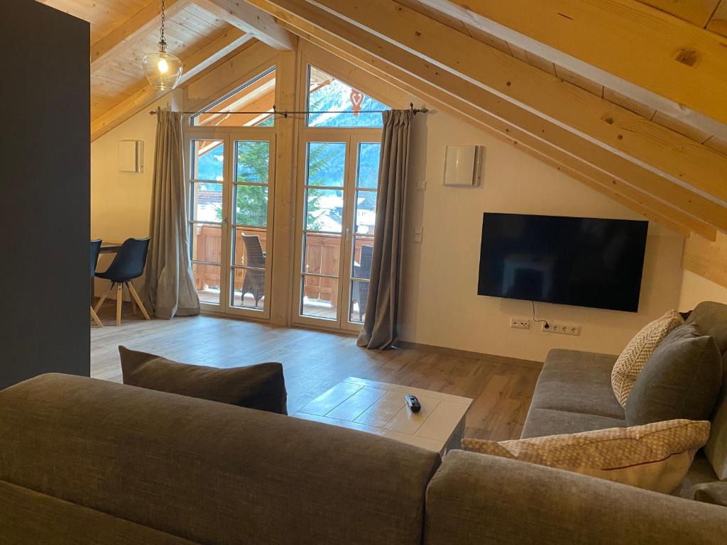 a living room with a couch and a flat screen tv at Ferienwohnung Schmetterer in Schliersee