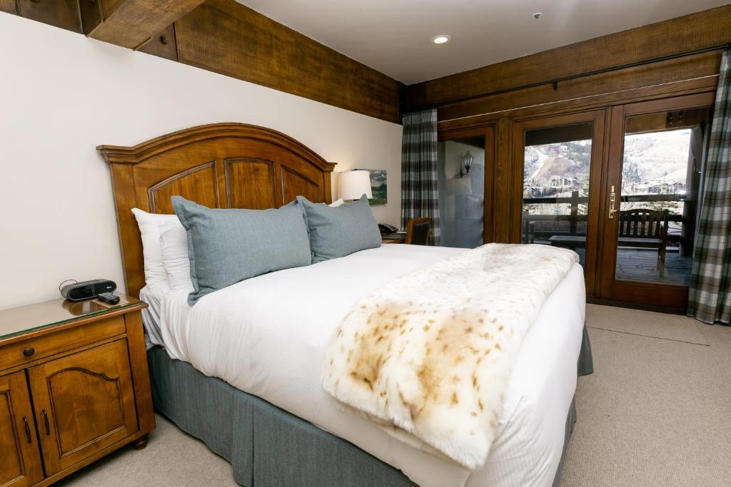 a bedroom with a large bed with a wooden headboard at Deluxe King Room with Deck Hotel Room in Park City