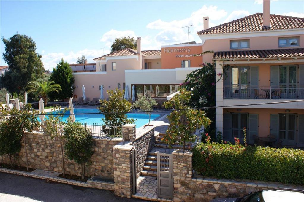 a villa with a swimming pool in front of a house at Harmony Hotel Apartments in Selianitika