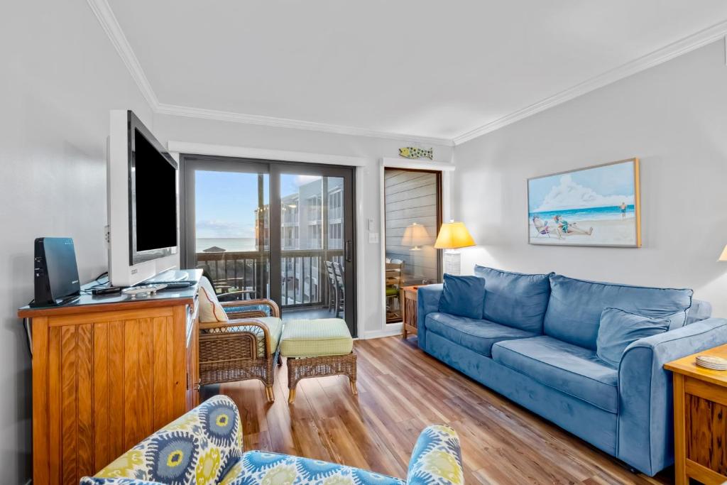 salon z niebieską kanapą i telewizorem w obiekcie Dunescape Villas 211 w mieście Atlantic Beach