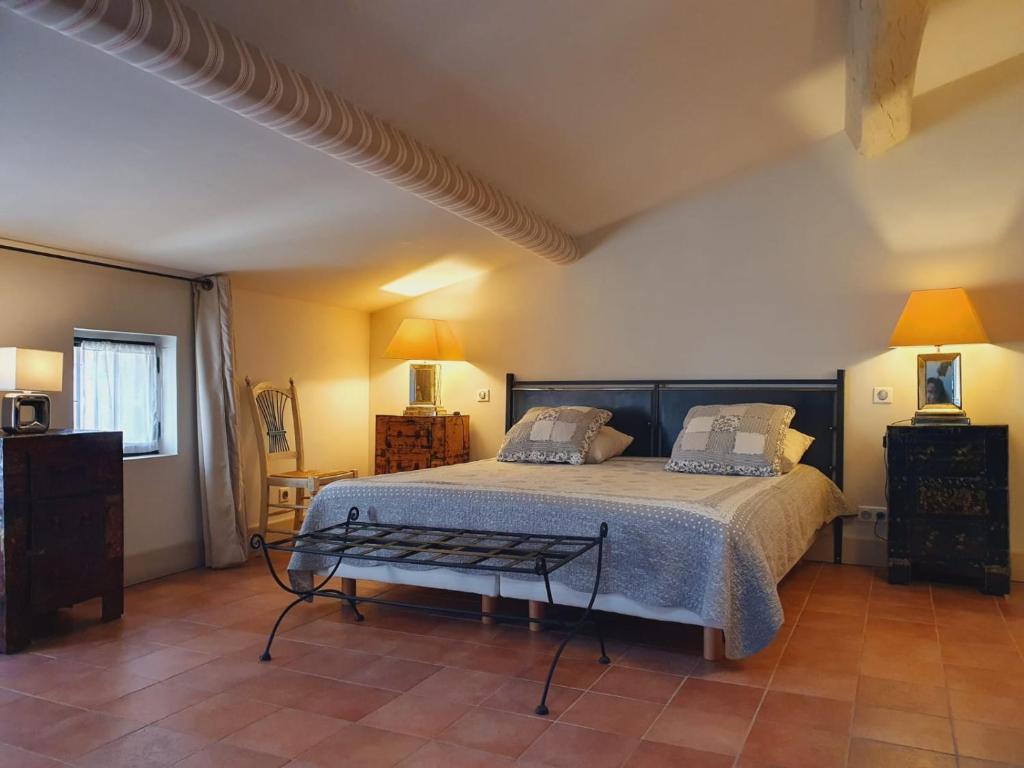 1 dormitorio con 1 cama grande y 1 mesa en La petite hostellerie, en Uzès