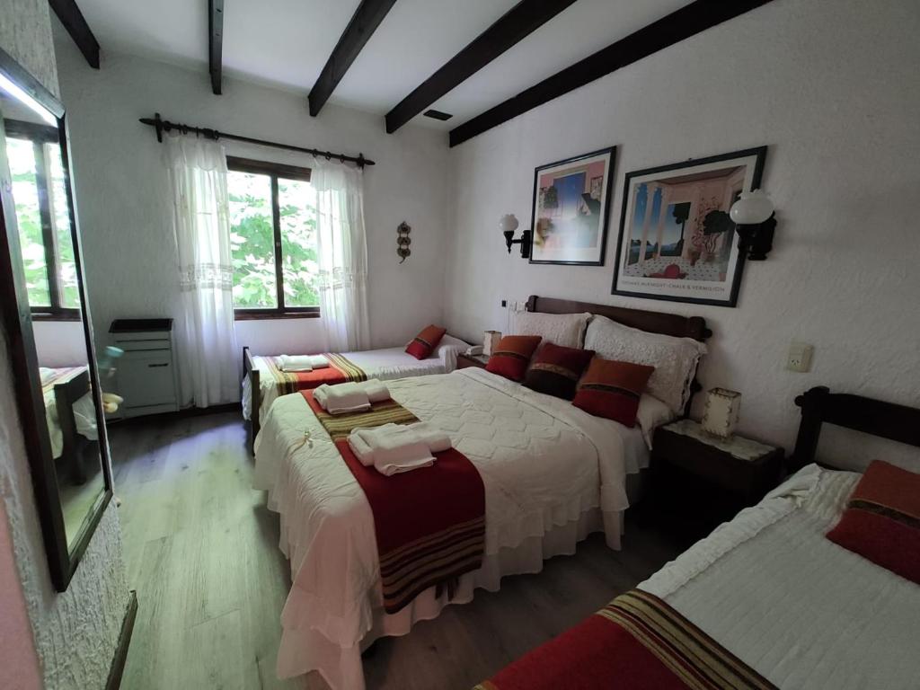 1 dormitorio con 3 camas, ventana y 2 camas en Hotel Boutique America en Miramar