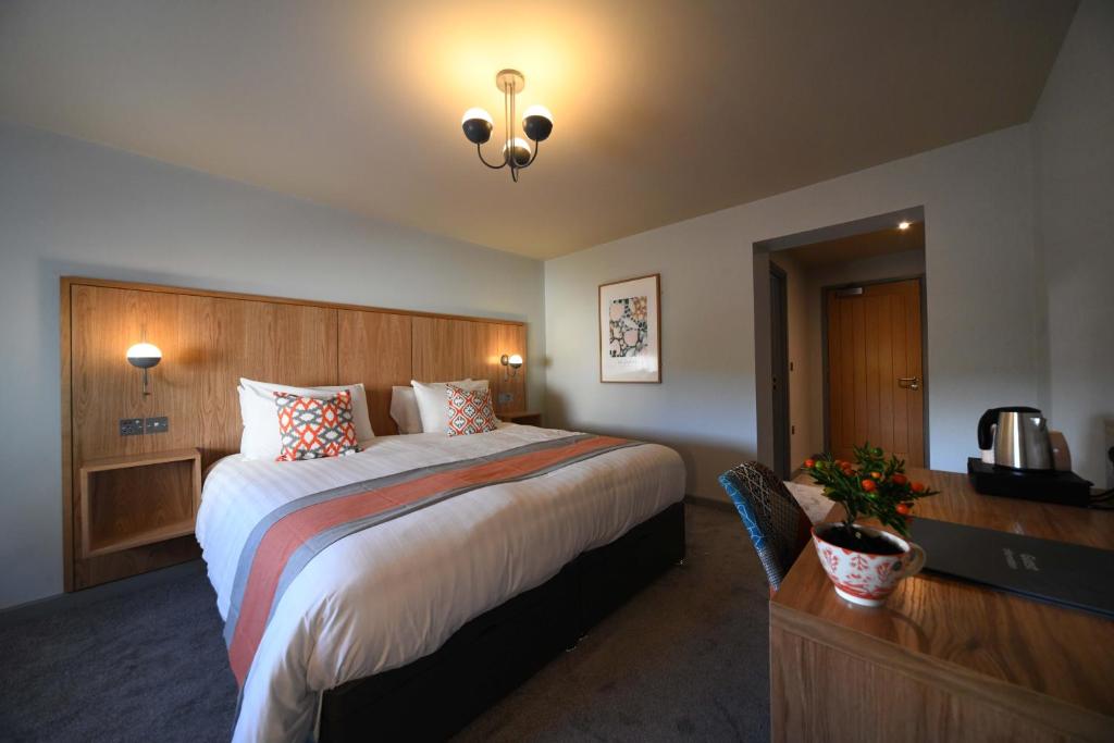 a hotel room with a large bed and a desk at Park Head Hotel in Bishop Auckland