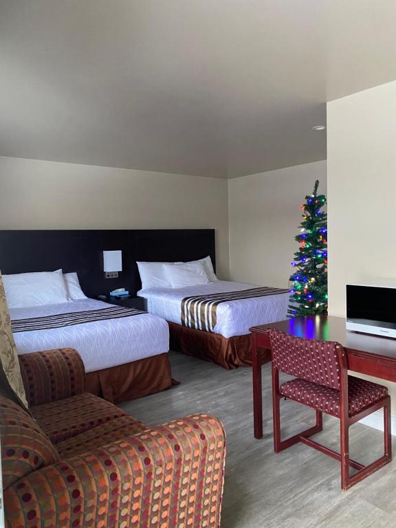 um quarto de hotel com duas camas e uma árvore de Natal em Silver Maple Motel em Haliburton
