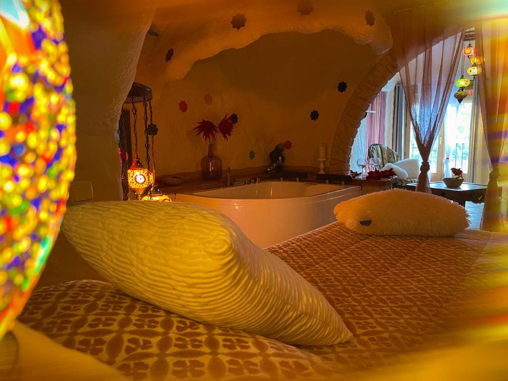 een badkamer met een bad en een bed met een kussen bij Casas cueva El Castaño in Pampaneira