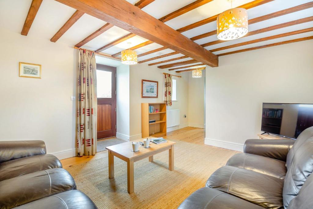 a living room with a couch and a table at Bwythyn-y-Wennol in Abersoch