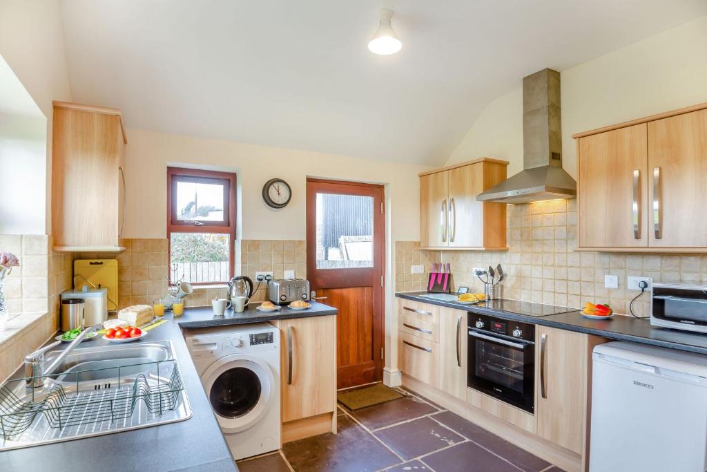 a kitchen with a sink and a dishwasher at Bwythyn-y-Wennol in Abersoch