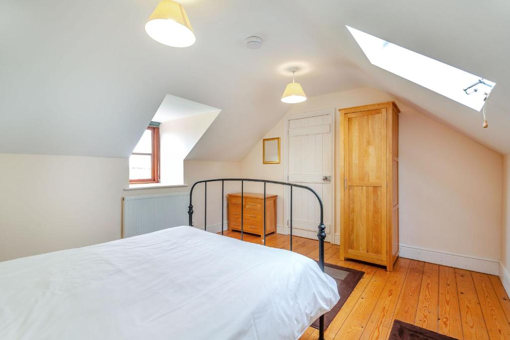 a bedroom with a white bed in a attic at Bwythyn-y-Wennol in Abersoch
