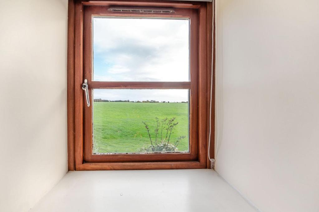 a window with a view of a green field at Bwythyn-y-Wennol in Abersoch