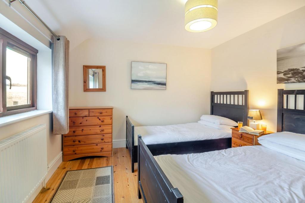 a bedroom with two beds and a window at Bwythyn-y-Wennol in Abersoch