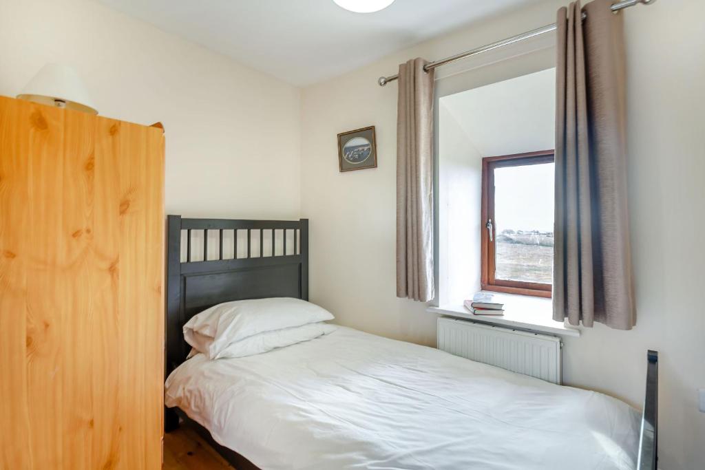 a bedroom with a bed and a window at Bwythyn-y-Wennol in Abersoch