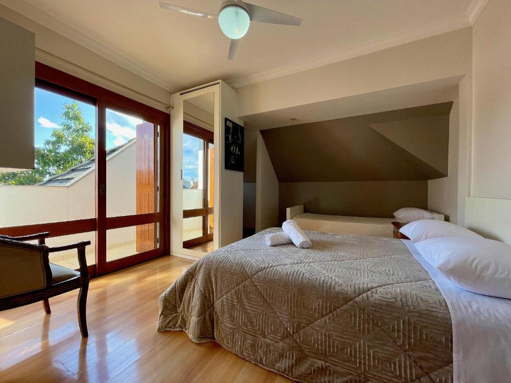 una camera da letto con un letto grande e una grande finestra di Apartamentos Dioserra CENTRO by Achei Gramado a Gramado