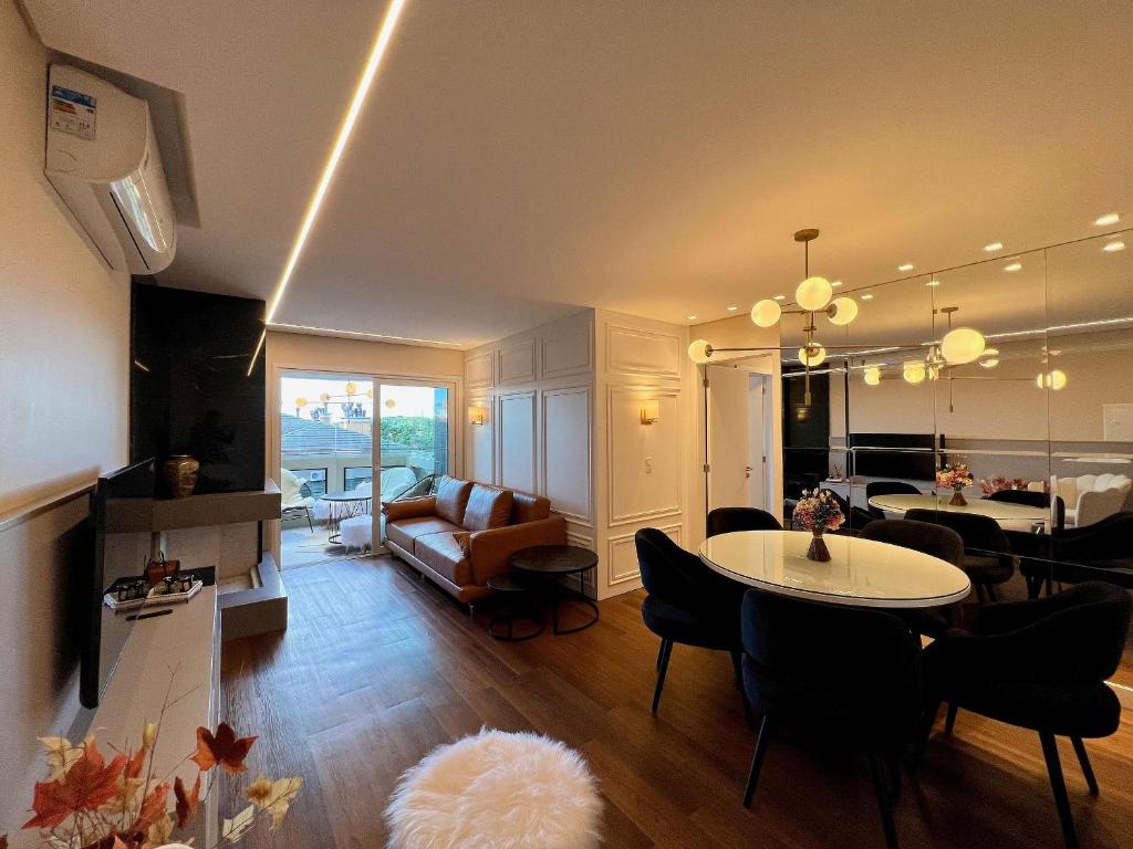 a living room with a dining table and a living room at Apartamento Beluno 3 dorm Canela by Achei in Canela