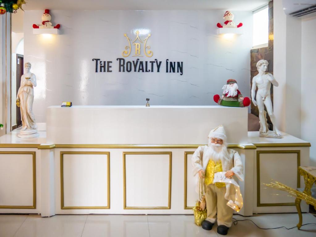 a santa clause standing in front of a table with statues at Hotel Boutique The Royalty in Guayaquil