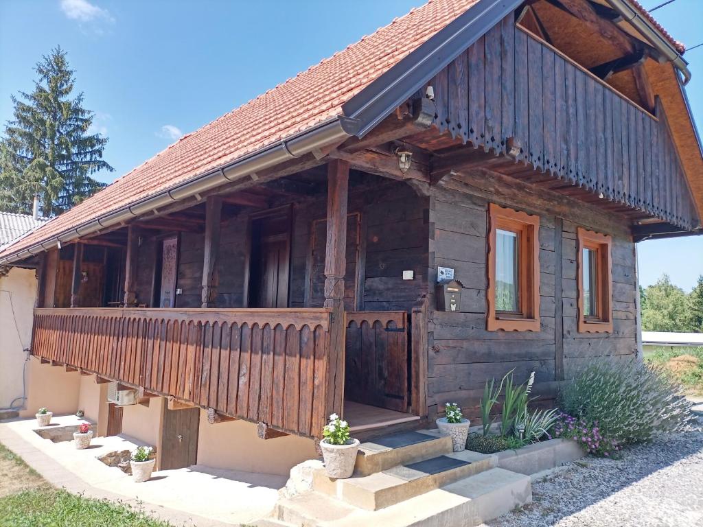 ein Holzhaus mit einem Tor davor in der Unterkunft Family friendly house with a swimming pool Mihalic Selo, Karlovac - 20284 in Duga Resa