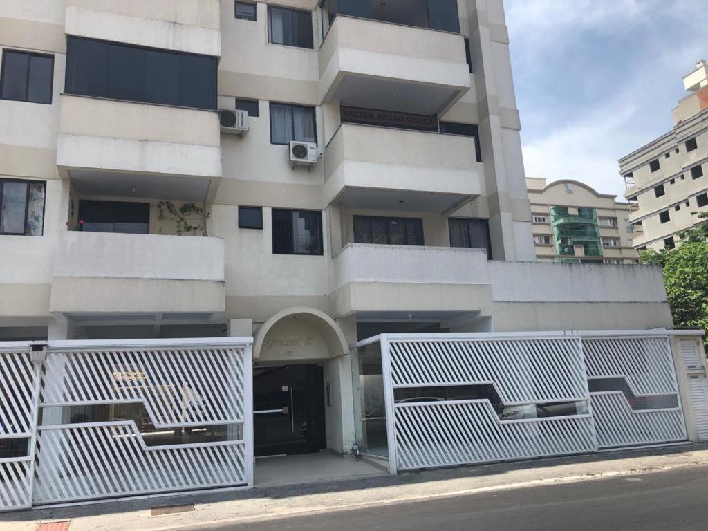 un edificio con puertas blancas delante de él en Simplicidade e aconchego, en Itapema