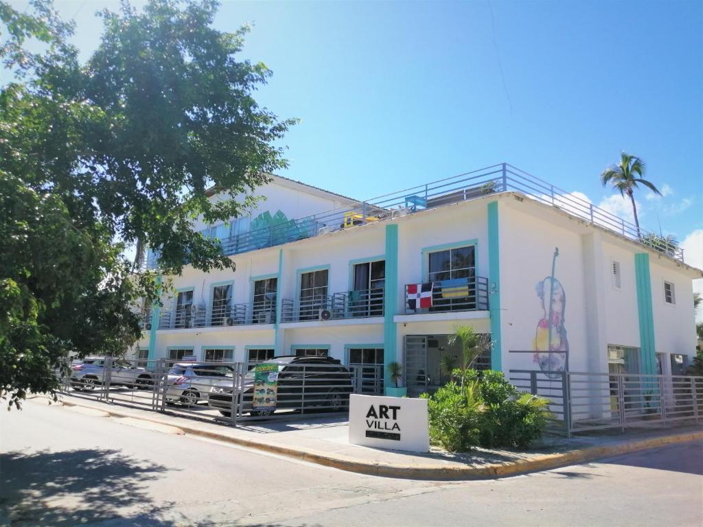 un bâtiment blanc avec un panneau devant lui dans l'établissement Art Villa, à Punta Cana