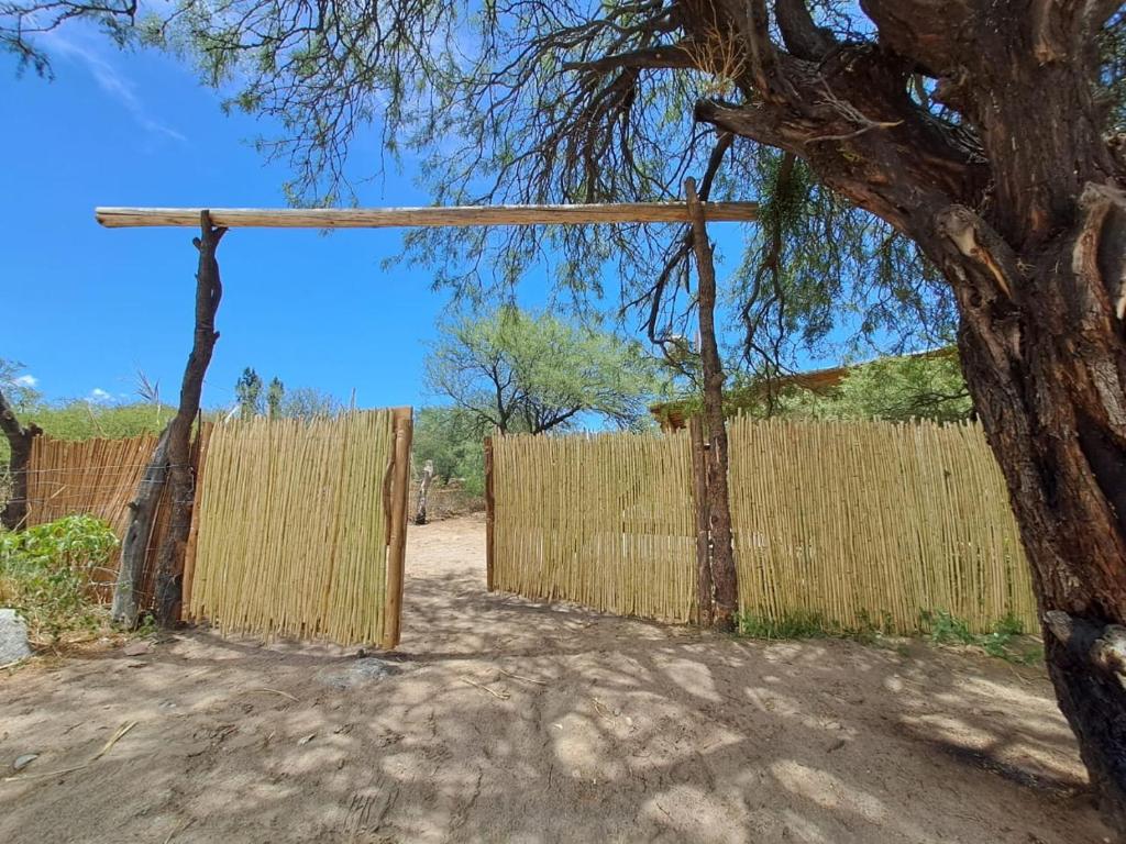 a wooden fence with a tree in front of it at La Mungana in Cafayate