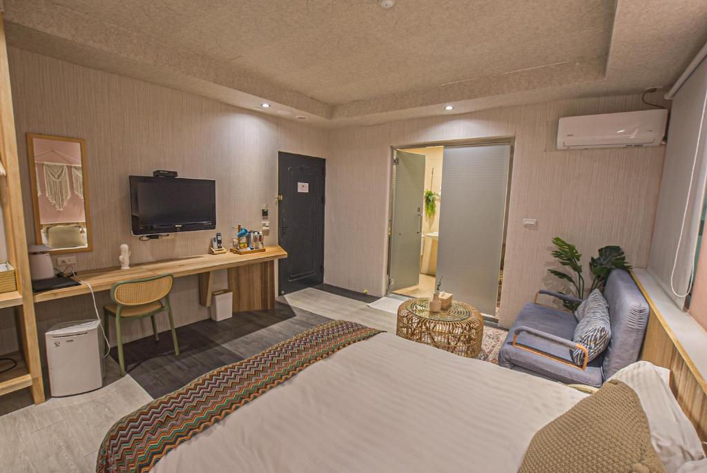 a hotel room with a bed and a desk at Ashare Hotel in Jiaoxi