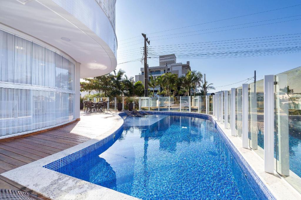 una piscina al lado de un edificio en Puntarenas 202 - Excelente apartamento 2 suítes - Finamente mobiliado e decorado - À poucos metros da praia, en Bombinhas