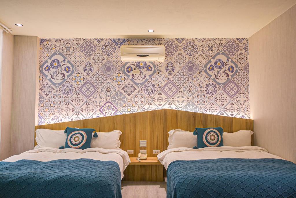 a hotel room with two beds and a wall at Ashare Hotel in Jiaoxi