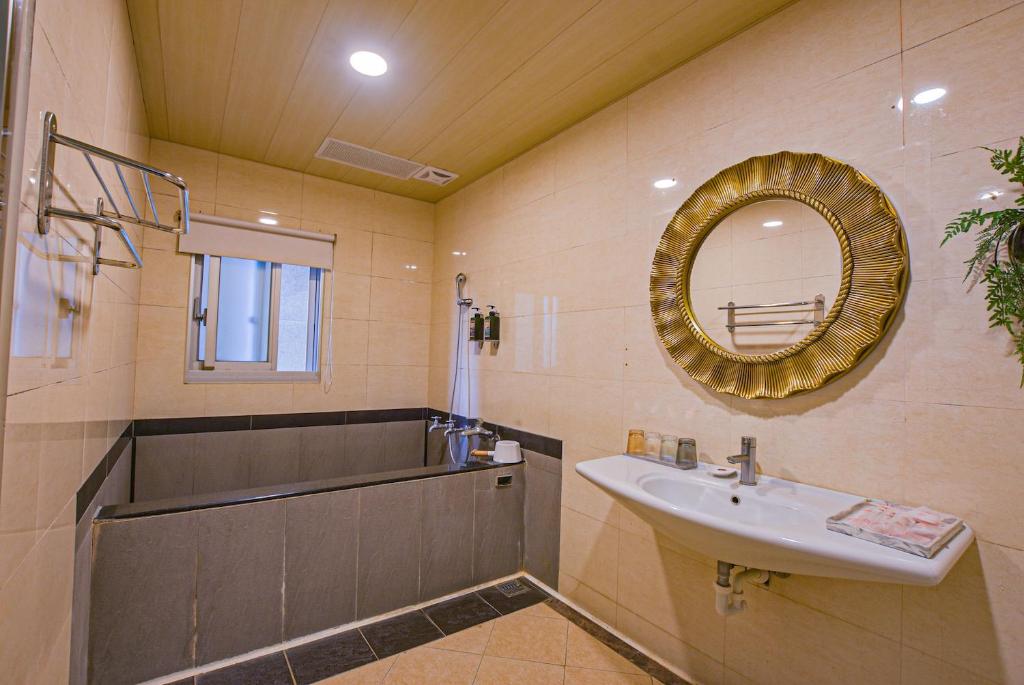 a bathroom with a sink and a mirror at Ashare Hotel in Jiaoxi