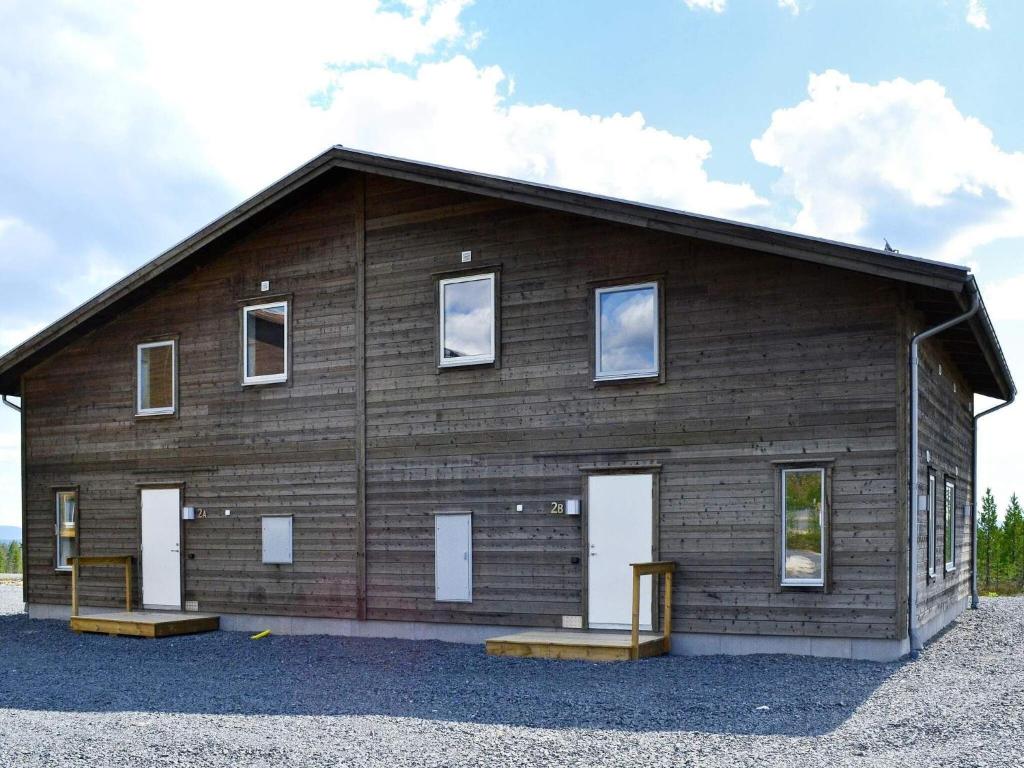 a large wooden barn with white doors and windows at Holiday home IDRE IV in Idre