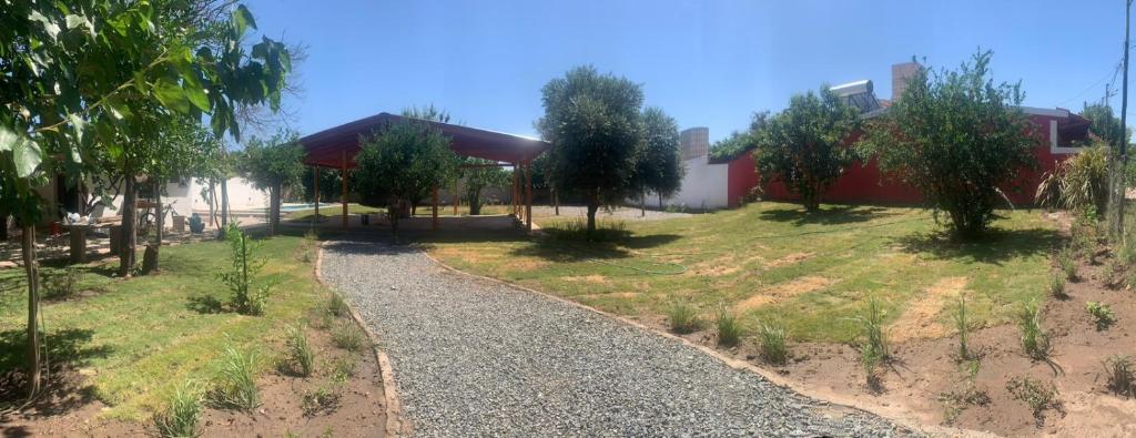 un chemin de gravier devant un bâtiment arboré dans l'établissement Zama - Complejo de cabañas, à Villa de Soto
