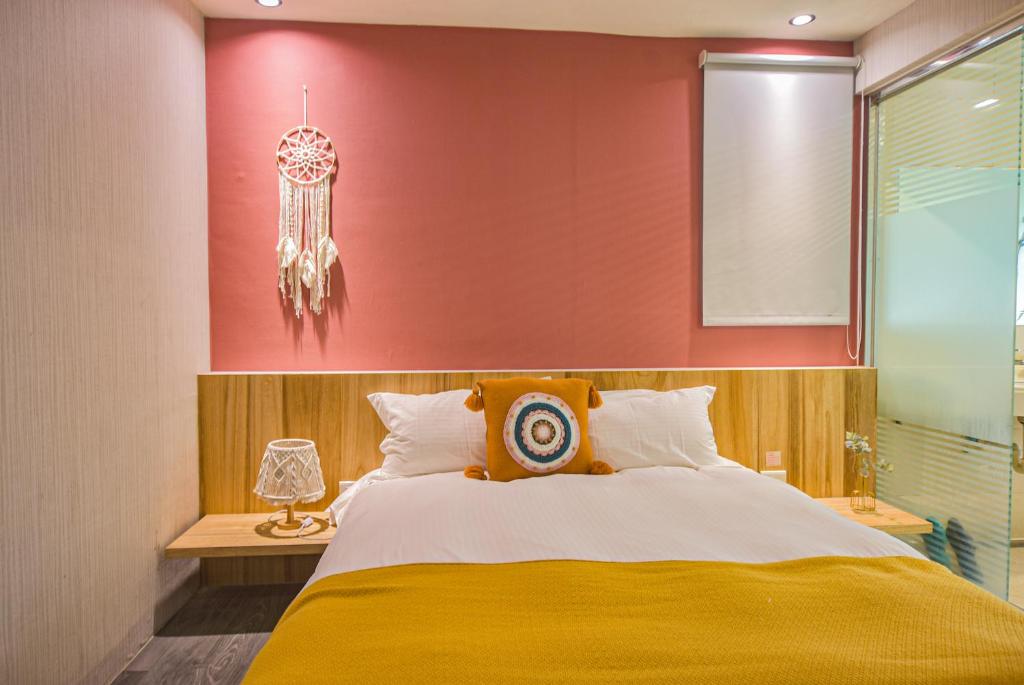 a bedroom with a large bed and a red wall at Ashare Hotel in Jiaoxi