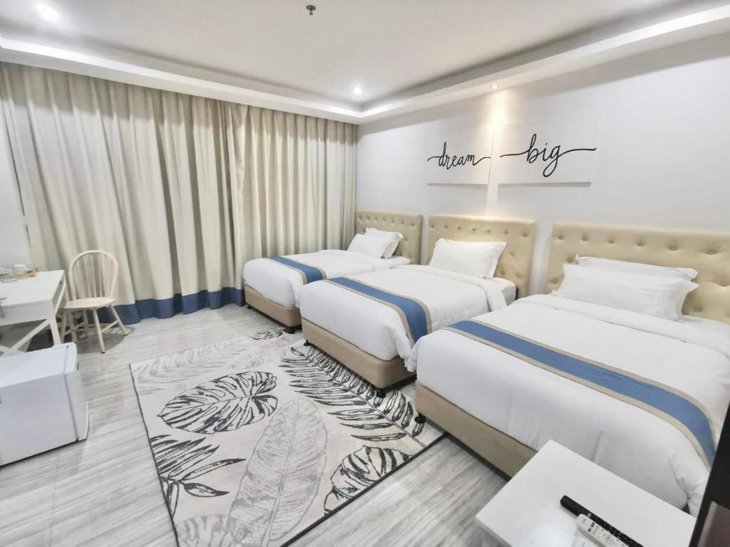 a hotel room with two beds and a desk at Hampton Suites in Davao City
