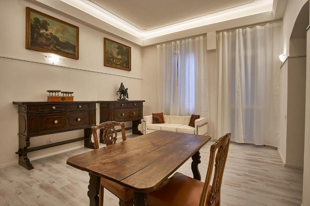 Cuore di Bologna Suites في بولونيا: غرفة معيشة مع طاولة خشبية وأريكة
