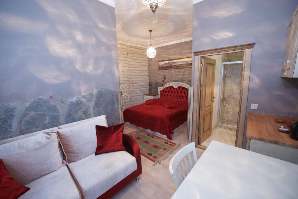 a living room with a couch and a red bed at Galatolia Suites in Istanbul