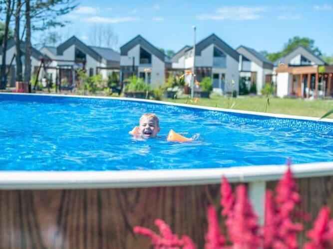 a young boy swimming in a swimming pool at Spacious holiday houses with air conditioning, swimming pool, sauna, Niechorze in Niechorze