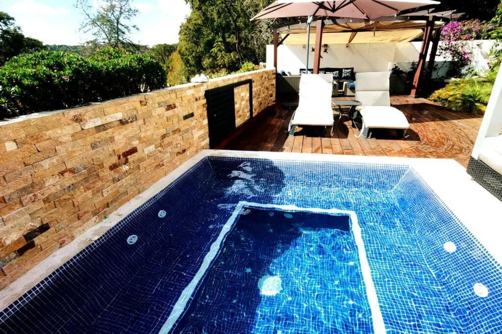 uma piscina num quintal com um guarda-sol em Casa Aguila Gran Reserva em Ixtapan de la Sal