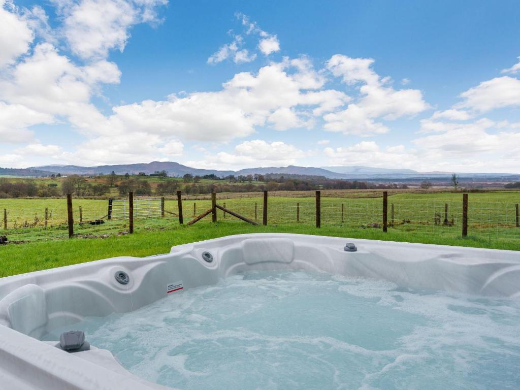 a hot tub with a view of a field at Gartclach-uk40001 in Gartmore