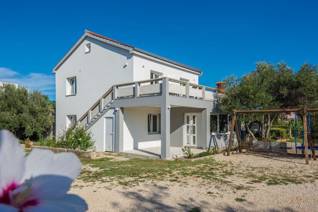 een wit huis met een trap ervoor bij Apartment Radovic Nives in Vir
