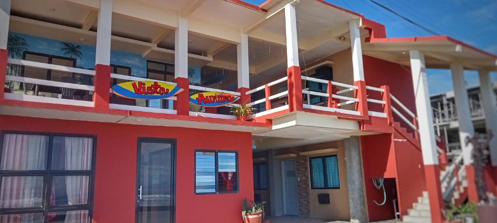 a red building with a balcony on the side of it at Vista Aurora in Baler