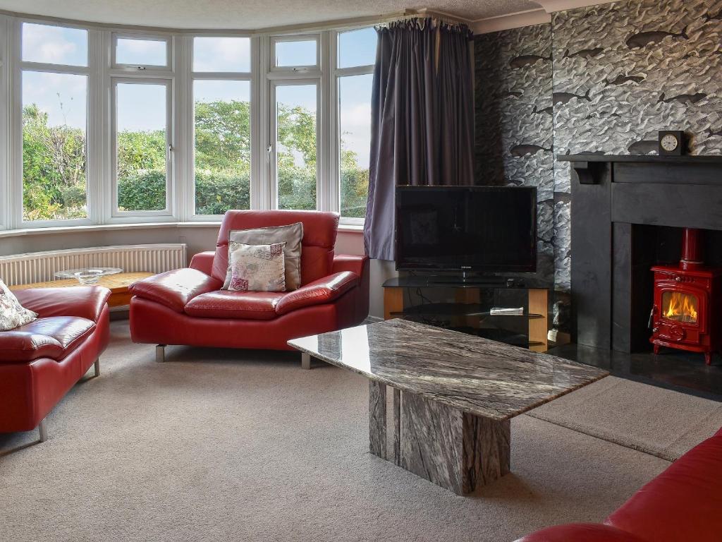 a living room with a fireplace and a tv at Westville in Criccieth